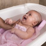 Cheerful baby having bath.