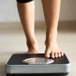 female-leg-stepping-on-weigh-scales-healthy-lifestyle-food-and-sport-picture-id1169486621