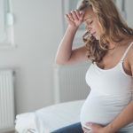 pregnant-woman-suffering-with-headache-and-nausea-picture-id653003570