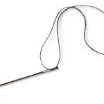 single-needle-with-black-thread-on-a-white-background-picture-id148795677