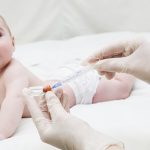 Infant child baby  creep and hand with medical insulin syringe