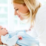 mother-lying-in-the-bed-and-holding-her-baby-boy-picture-id171322378