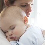 Mother With Her Baby Boy Sleeping In Her Arms