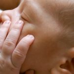 close up of newborn baby near breast