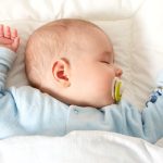 Four month old baby sleeping on blue blanket