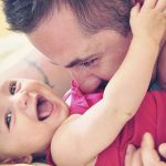 Father with smiling baby daughter dressed in red