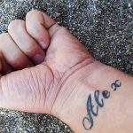 Tattoo with the name of Alex on the hand of a man