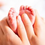 hand-with-newborn-babys-foot-picture-id1141152602