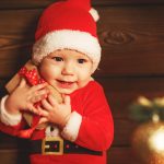 Happy baby  with gift at christmas tree