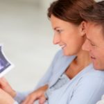 Portrait of a happy parents couple holding a sonogram of their unborn child