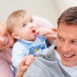 Portrait of a happy young couple playing with their cute newborn baby
