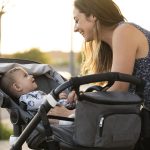 Mother and her son in the baby stroller at the door of their house