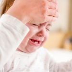 mother-checking-babys-temperature-with-her-hand-picture-id922802724
