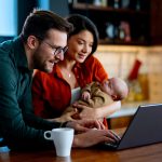 Shot of a happy young family using a laptop together at home