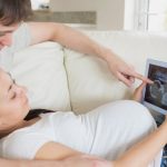 Prospective parents looking at ultrasound scan on tablet pc