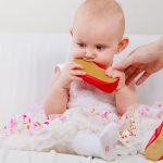 Baby girl biting shoe