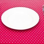 Empty white dinner plate with utensils