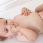 Mother changing diapers of a cute baby boy