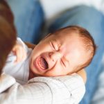 woman-holding-a-crying-child-mother-comforts-her-little-son-or-picture-id1217996596