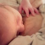 close-up view of a newborn baby feeding with breast milk