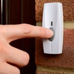 Close-up of woman pressing a doorbell