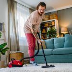 Man cleaning house with vacuum cleaner