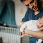 dad-holding-crying-baby-in-the-colic-carry-picture-id987444524