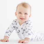 Portrait of cute smiling and lying baby boy in romper.