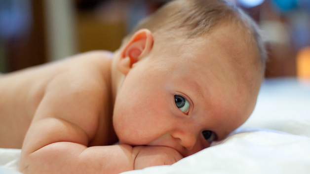 Begynn tidlig å venne barnet til å ligge på magen. Gjør det gjerne i forbindelse med bleieskift.