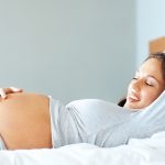 Beautiful pregnant lady relaxing on a bed