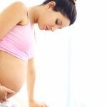 Pregnant woman carefully standing up.