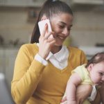 mother-working-at-home-mother-holding-her-little-baby-in-arms-picture-id857795586