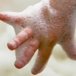 child-hand-with-soap-bubbles-picture-id526299484