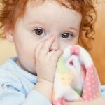 little-girl-sucking-thumb-with-blanket-picture-id172381916