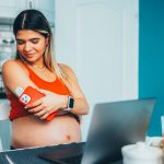 Pregnant woman with diabetes monitoring blood sugar on phone