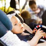 little-baby-girl-fastened-with-security-belt-in-safety-car-seat-picture-id864569320