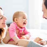 mother-father-and-baby-child-on-a-white-bed-picture-id854148544