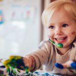 happy-little-child-having-fun-doing-finger-painting-at-home-picture-id983439956