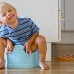 little-toddler-boy-sitting-on-potty-playing-with-wooden-toy-picture-id1157714770