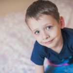 the-happy-boy-sits-on-the-bed-view-from-above-child-looks-at-the-picture-id1226797776