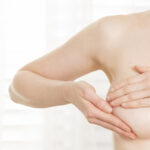 Young woman performing breast cancer self-exam