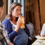 pregnant-woman-having-juice-with-friends-at-table-picture-id654401461
