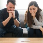 Hispanic couple looking at a home pregnancy test