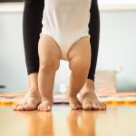 Baby’s feet taking steps learning to walk with mothers help.