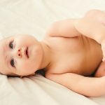 Naked baby on a light background.