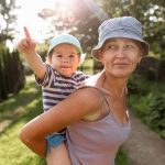 Loving grandmother and granddaughter playing and laughing together in garden in the summer