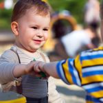 Two toddler boys hanging out on a playground