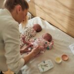 Mother is taking care of newborn twin babies