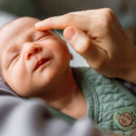 Little baby boy enjoying in mother’s touch